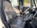 Interior of a 2012 International DuraStar 4300 showing two leather seats and the steering wheel with dashboard controls visible