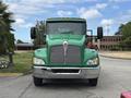 A green 2013 Kenworth T370 truck with a prominent grille and large headlights facing forward