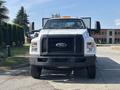 A white 2018 Ford F-750 with a large front grille and black bumper parked facing the viewer with visible side mirrors and an orange light bar on top