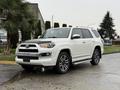 A 2018 Toyota 4Runner in white with silver accents parked with a prominent grille and sporty design
