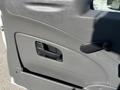 A close-up of a gray door panel from a 2013 International 7500 featuring a handle and a window crank