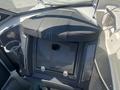 A 2013 Larson 238 boat seat with a black padded top and a storage compartment below featuring a small camera or speaker opening