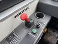 A control panel featuring a red gear shift lever a green start engine button and an odor controller with operational instructions