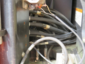 Close-up of various hydraulic hoses and connections inside a 2009 JLG E300AJP machine displaying a mixture of metal and rubber components
