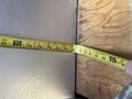 A measuring tape being held against a surface with measurements visible ranging from 72 to 84 inches