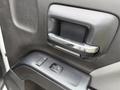 Close-up of a door handle and window control buttons on a 2016 GMC Sierra 1500 interior door panel