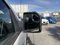 A side mirror of a 2018 Ford F-150 showing its reflective surface with an adjacent vehicle partially visible in the background