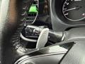 A close-up of a 2016 Mitsubishi Outlander steering wheel with controls for lights and wipers visible on the left side of the wheel and a speedometer on the right