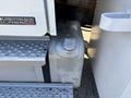 A close-up of a fuel tank on a 2006 Freightliner M2 106 truck showing a round cap on top and a textured surface