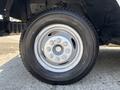 A close-up of a black tire and silver wheel from a 2012 Ford Econoline showing six lug nut holes and a tread pattern