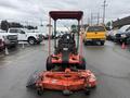 Red 2015 Kubota F3990 riding mower with a front-mounted mower deck and a protective canopy visible from the rear angle