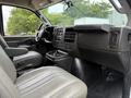 Interior view of a 2021 Chevrolet Express showing the driver's seat and dashboard with controls and storage compartments visible