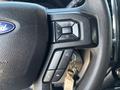 Close-up of the steering wheel of a 2017 Ford F-550 showcasing control buttons for volume and phone features