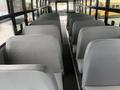 A row of gray bus seats in a 2007 Freightliner B2 with no passengers visible