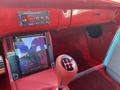 A 1962 Ford 2WHDR interior featuring red upholstery a touchscreen display and a manual gear shift with a five-speed pattern