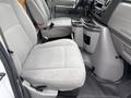 Interior of a 2024 Ford E-450 showing two gray cloth seats and a dashboard with controls and a console between the seats