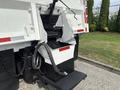 A 2013 International WorkStar truck with visible hydraulic lift components and a metal frame designed for waste collection or similar heavy-duty tasks