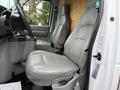 Interior of a 2019 Ford Econoline featuring two gray leather front seats with armrests and a central console between them