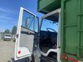 A 1997 Freightliner FL70 with an open driver's door revealing the steering wheel and dashboard inside the cab