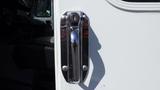 A chrome handle with a keyhole on the side door of a 2004 Freightliner MT45