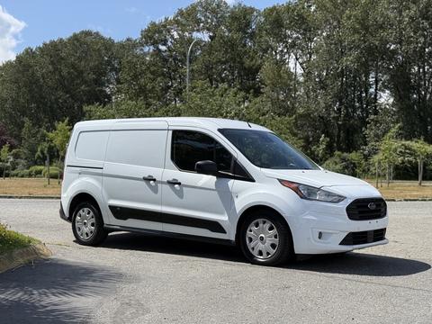 A white 2021 Ford Transit Connect van parked with its side facing the viewer showcasing its sleek design and spacious cargo area