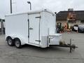 A 2016 Continental cargo trailer featuring a white exterior dual axles and a side door with a metal latch