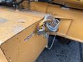 A lock and chain attached to a hydraulic fluid cap on a yellow 2005 Case 570 construction vehicle