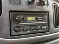 A dashboard display of a 2008 Ford Econoline featuring a radio with buttons for volume, tone, and station tuning