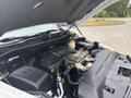 A 2016 RAM 1500 engine compartment featuring the engine block various hoses and the coolant reservoir