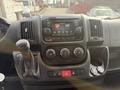 The interior dashboard of a 2017 RAM Promaster featuring a central touchscreen display multiple control knobs and a gear shift lever
