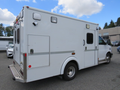 A 2011 Chevrolet Express van designed as an ambulance with a white exterior and emergency lights on top
