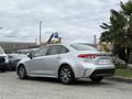 A silver 2025 Toyota Corolla parked with a sleek design showcasing its modern shape and distinctive rear lights