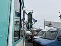 A 2020 Freightliner MT45 showing a side view mirror and the truck's cab with a teal and white color scheme