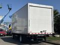 A 2018 Hino 195 box truck with a plain white cargo area and a rear loading door parked in a lot