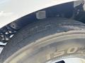 Close-up of a worn tire on a 2015 Ford F-750 showing visible tread wear and slight damage on the sidewall