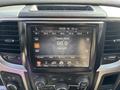 A 2014 RAM 5500 vehicle dashboard featuring a touch screen displaying radio information and various control buttons