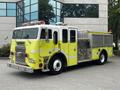 A 1995 Freightliner FLL086 fire truck painted in bright yellow with red lights on top and fire equipment on the sides