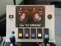 Control panel of a 2012 International 7400 featuring various switches and dials for hydraulics and spreader controls labeled EZ SPREAD