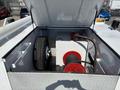 A 2017 Ford F-550 with an open truck bed revealing storage space containing a spare tire a red winch and equipment for towing