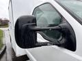 A 2000 Ford F-450 with a close-up view of its side mirror showing water droplets on the surface