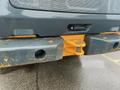 Close-up of a 2016 Hyundai HL940's rear bumper featuring a yellow tow hitch and visible wear with rust on the surface