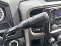 A close-up of a black gear shift lever with buttons for adjusting settings in a 2016 RAM 5500 interior