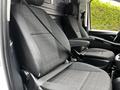 Interior view of a 2020 Mercedes-Benz Metris showing two front seats with black fabric upholstery and seat belts positioned in a van-style layout