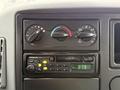 The dashboard controls of a 2006 International 4200 featuring dials for climate control and a Panasonic radio display with frequency settings