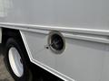 Detail of a 2008 Ford Econoline showing a round fuel cap with a metal latch on the side of the vehicle