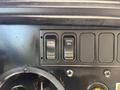 The image shows the control panel of a 2013 International CE300 featuring switches labeled DISAB TRAC ENAB ON PARKD REGEN