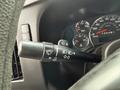 Close-up view of the control stalk on a 2013 Chevrolet Express featuring buttons for headlights wipers and turn signals
