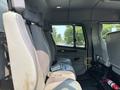 Interior view of a 1999 Freightliner FL80 cab featuring gray bucket seats with seatbelts and a single bench seat without any occupant