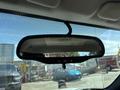 Rearview mirror of a 2011 Chevrolet Colorado with a clear view of its reflective surface and controls located below the mirror
