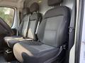 The interior of a 2017 RAM Promaster featuring two black fabric front seats with adjustable headrests and a console between them